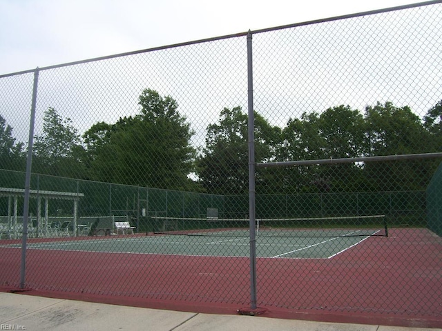 view of tennis court featuring fence