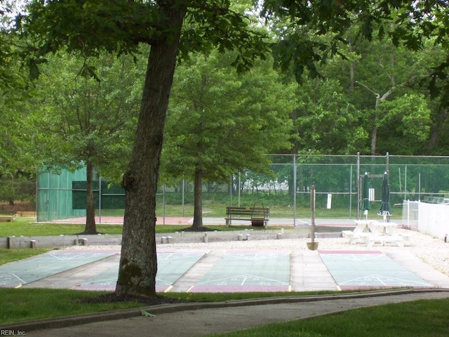 view of property's community with fence and shuffleboard