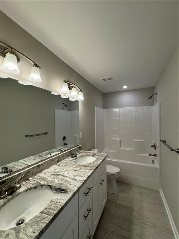 full bath with toilet, shower / tub combination, a sink, and visible vents