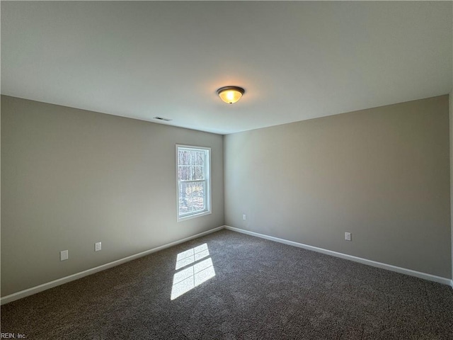 empty room with baseboards, visible vents, and carpet flooring
