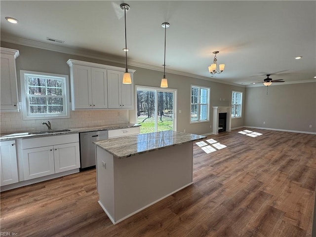 kitchen featuring stainless steel dishwasher, a sink, visible vents, and white cabinetry