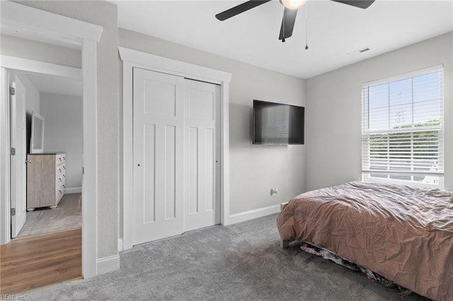 bedroom with a closet, visible vents, a ceiling fan, carpet flooring, and baseboards