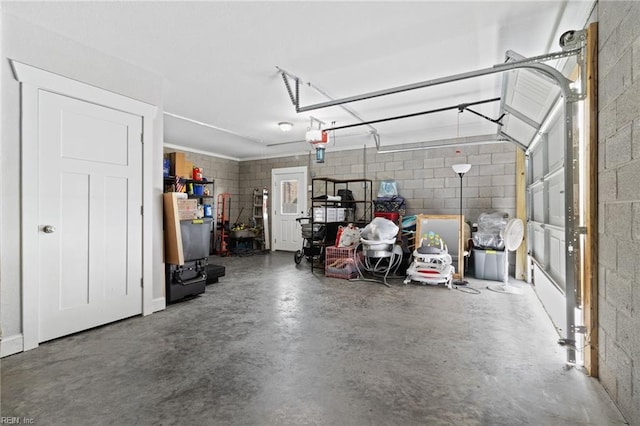 garage with concrete block wall and a garage door opener