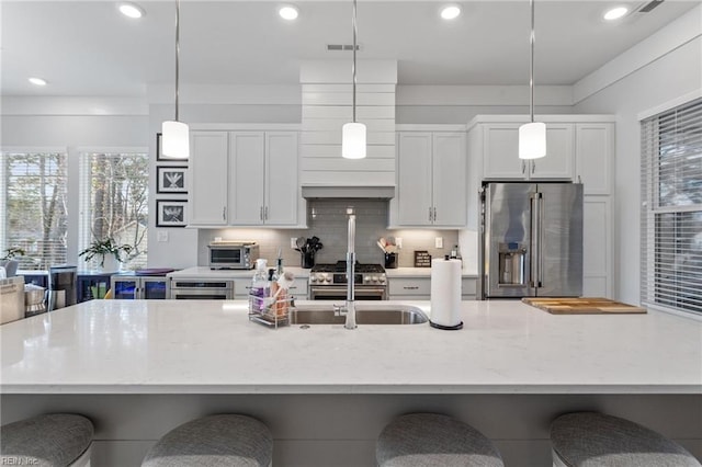 kitchen with visible vents, white cabinets, high quality appliances, and decorative backsplash