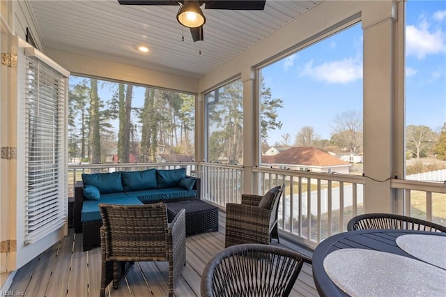 sunroom / solarium featuring a healthy amount of sunlight and ceiling fan