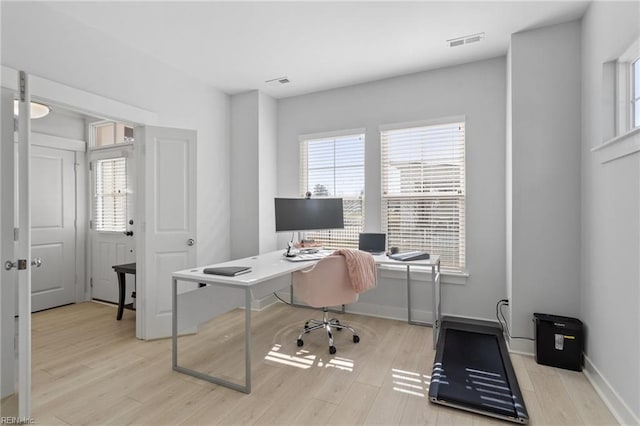 office area with visible vents, baseboards, and wood finished floors