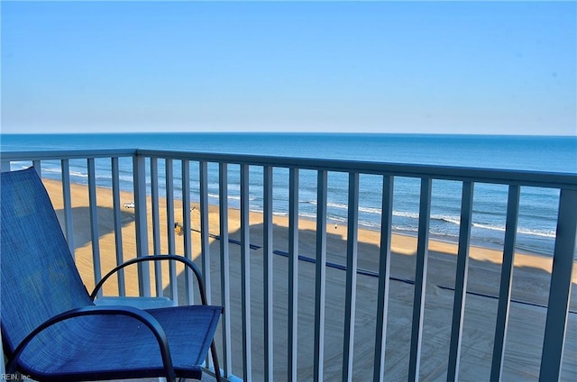 balcony with a water view and a view of the beach