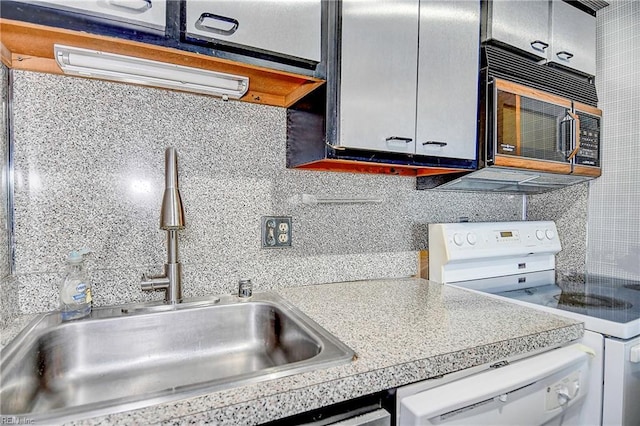 kitchen with white appliances, light countertops, a sink, and backsplash