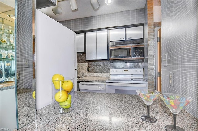 kitchen featuring white appliances and backsplash