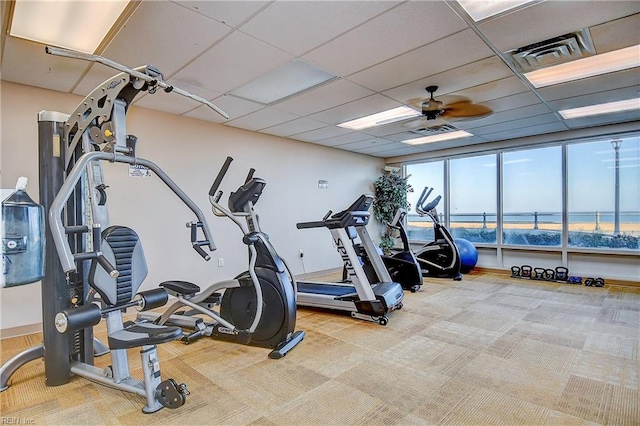 gym featuring carpet, visible vents, ceiling fan, and a paneled ceiling