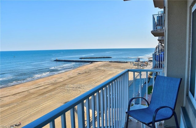 balcony with a water view and a view of the beach