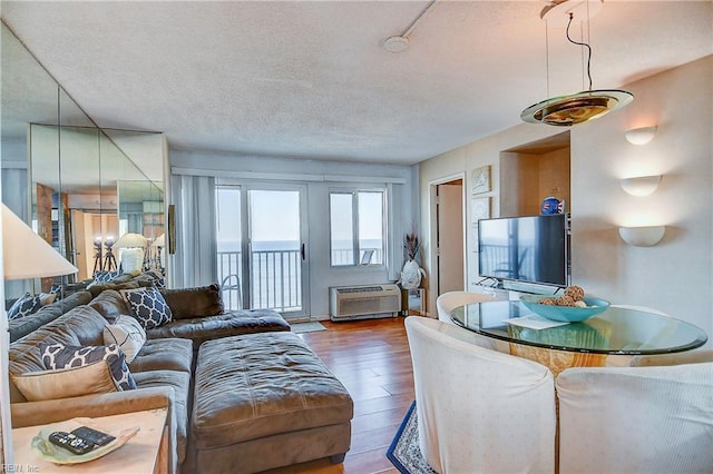 living area with a textured ceiling and wood finished floors