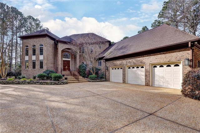 view of front facade featuring brick siding, concrete driveway, and a shingled roof