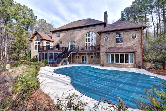 view of swimming pool featuring a deck, fence, a fenced in pool, stairs, and a patio area