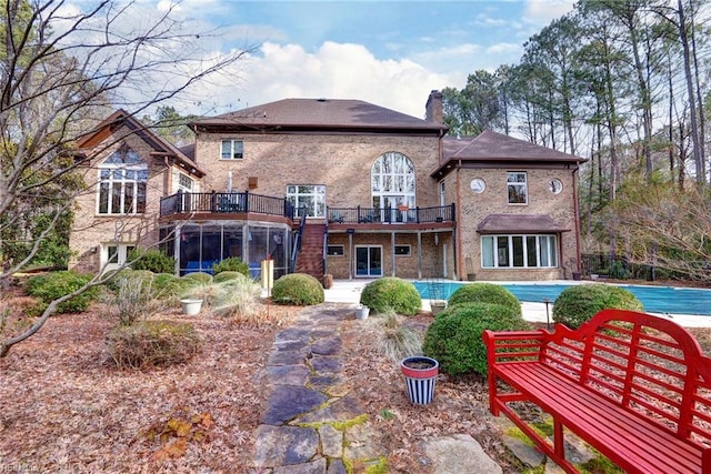 rear view of property with brick siding and a chimney