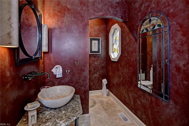 bathroom featuring vanity, baseboards, and visible vents