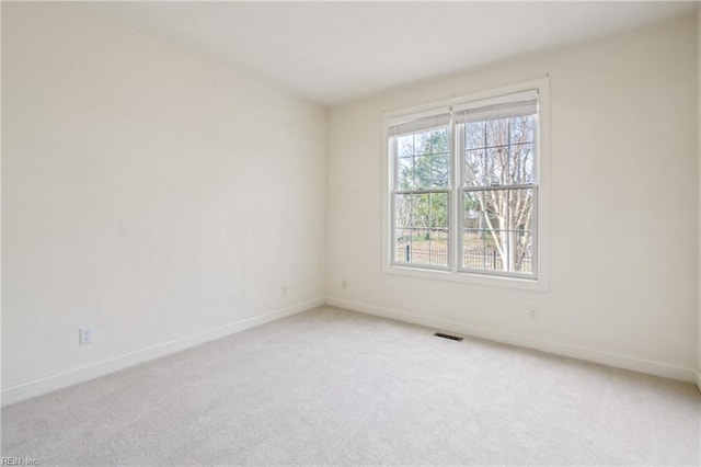 unfurnished room featuring light colored carpet, visible vents, and baseboards