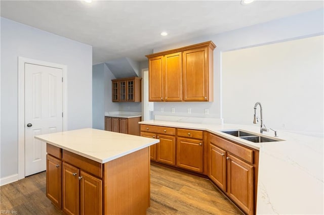 kitchen with recessed lighting, brown cabinets, a sink, and wood finished floors