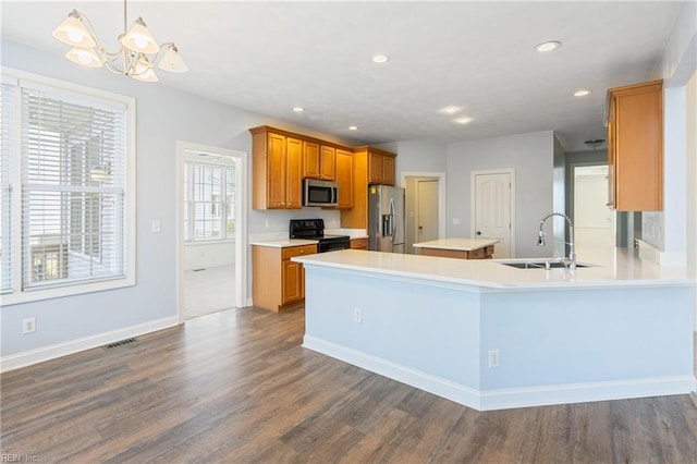 kitchen featuring stainless steel appliances, light countertops, dark wood-type flooring, and a sink