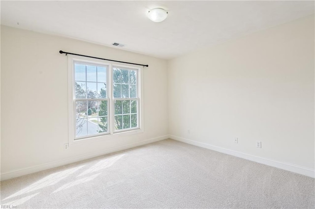 carpeted spare room with visible vents and baseboards