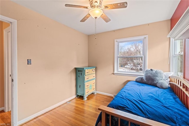 bedroom featuring light wood finished floors, ceiling fan, and baseboards