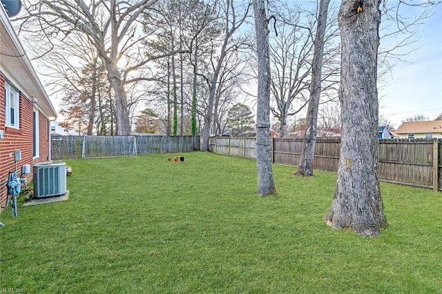 view of yard with a fenced backyard and central AC unit