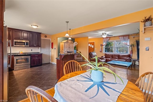 dining room with dark wood finished floors, ceiling fan, and baseboards