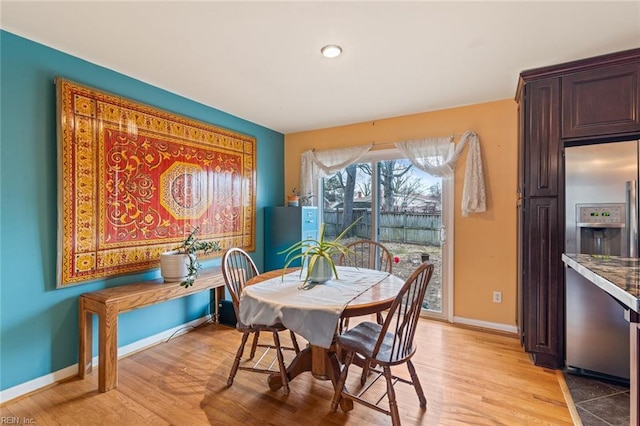 dining room featuring light wood finished floors and baseboards