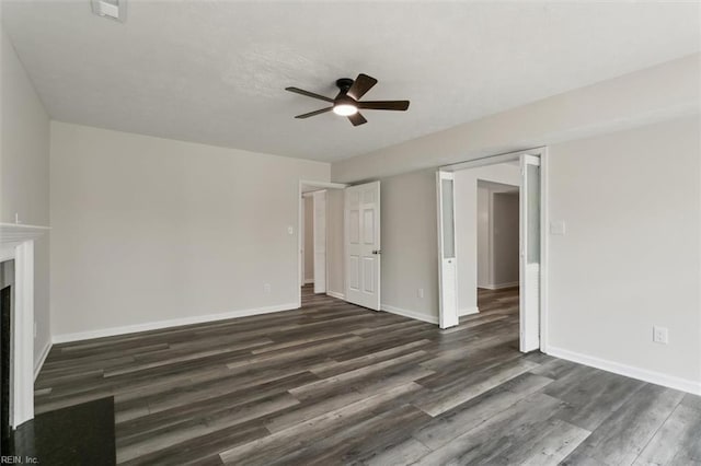 unfurnished living room featuring a ceiling fan, a fireplace, baseboards, and dark wood-type flooring