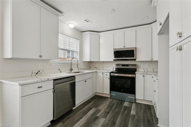 kitchen with visible vents, dark wood finished floors, appliances with stainless steel finishes, white cabinetry, and a sink