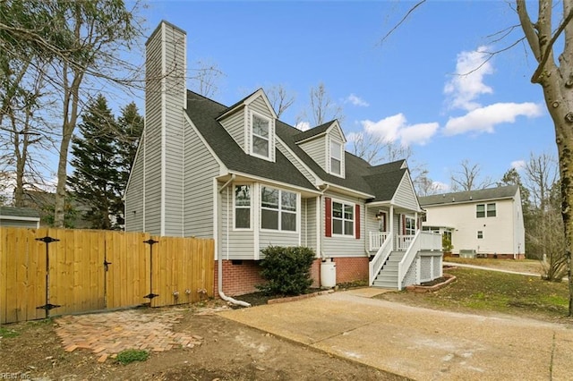 view of front of property with a gate, a chimney, fence, and roof with shingles