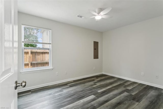 unfurnished room featuring a ceiling fan, electric panel, baseboards, and dark wood-type flooring