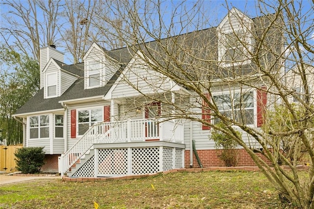 cape cod house with roof with shingles and a front yard