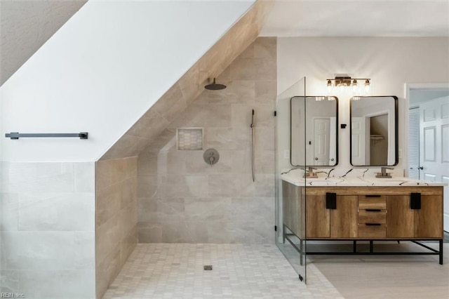 full bath featuring double vanity and a tile shower