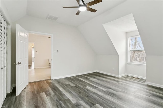 bonus room featuring lofted ceiling, wood finished floors, visible vents, and baseboards