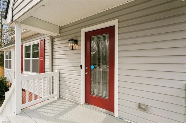 view of exterior entry with a wooden deck