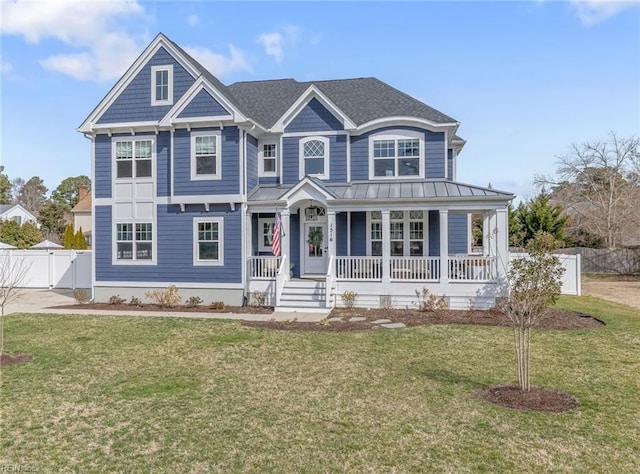 view of front of home with a standing seam roof, a gate, a porch, fence, and a front yard