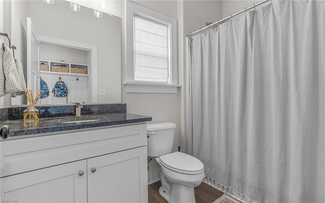 bathroom with vanity, a shower with curtain, toilet, and wood finished floors