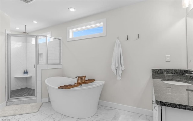 full bath with baseboards, a stall shower, a freestanding tub, marble finish floor, and vanity