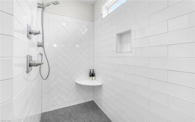 full bath with a tile shower