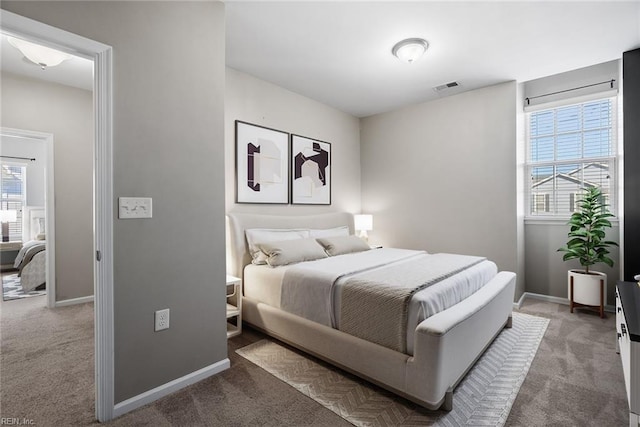 bedroom featuring carpet floors, visible vents, and multiple windows