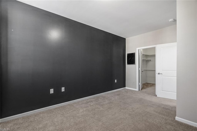 empty room featuring carpet and baseboards