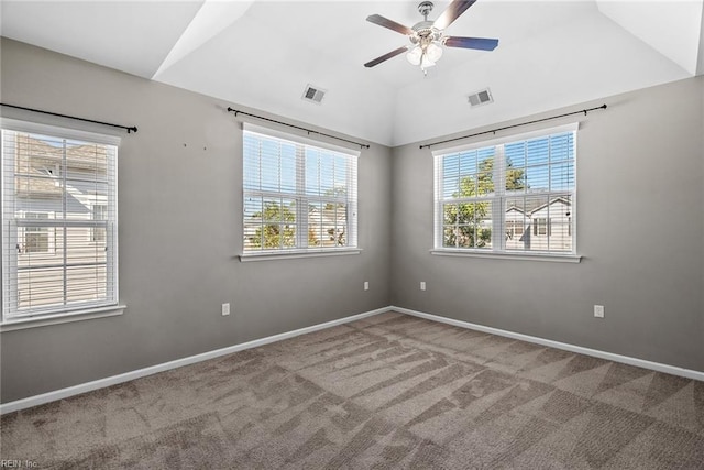 carpeted empty room with a ceiling fan, visible vents, vaulted ceiling, and baseboards