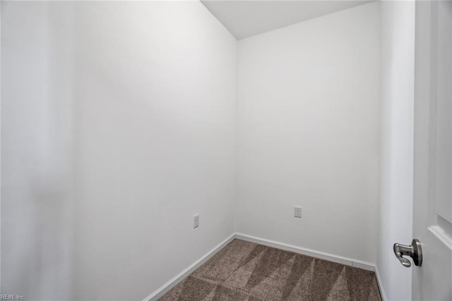 unfurnished room with dark carpet and baseboards