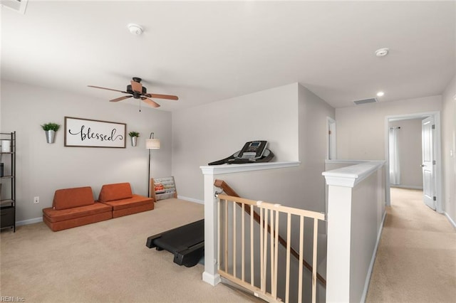 interior space featuring carpet flooring, visible vents, baseboards, and an upstairs landing