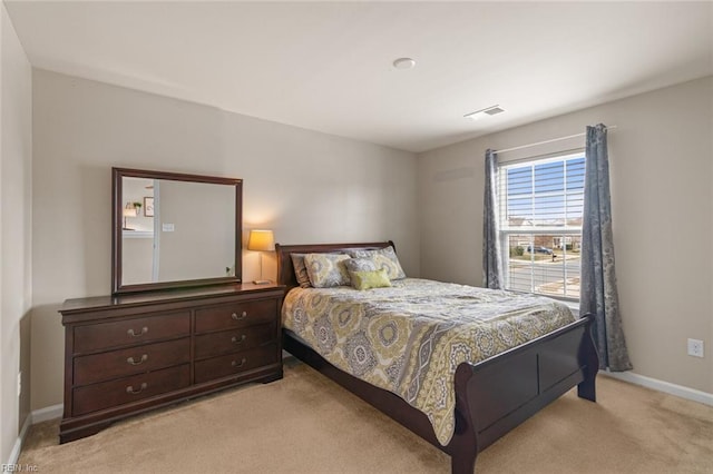 bedroom with light carpet, visible vents, and baseboards