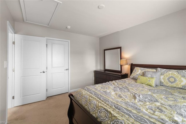 bedroom featuring light carpet and attic access