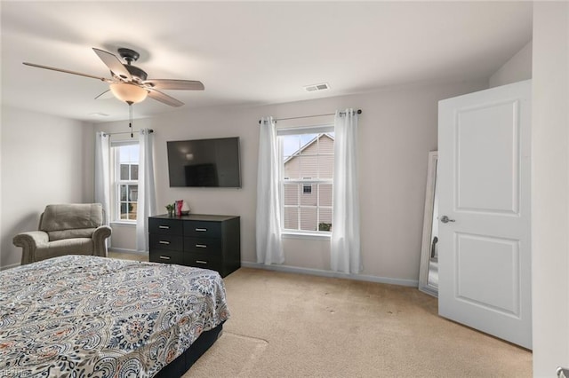 bedroom with light carpet, baseboards, multiple windows, and visible vents