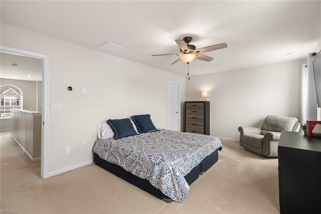 bedroom featuring light colored carpet, ceiling fan, visible vents, and baseboards