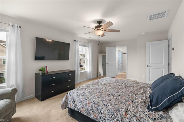 bedroom with baseboards, visible vents, ceiling fan, and light colored carpet